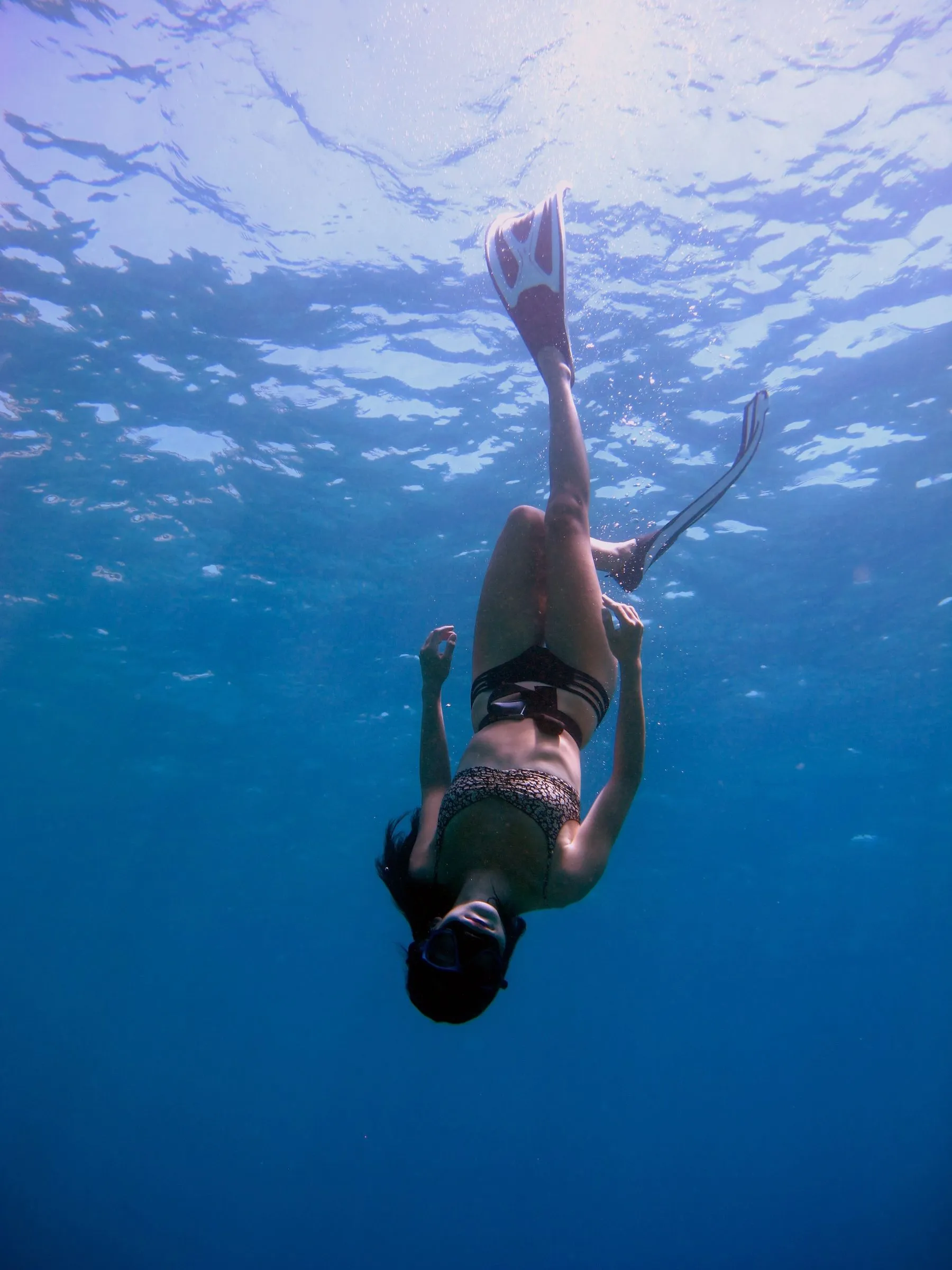 Freediver die ontspannen door helder blauw water beweegt