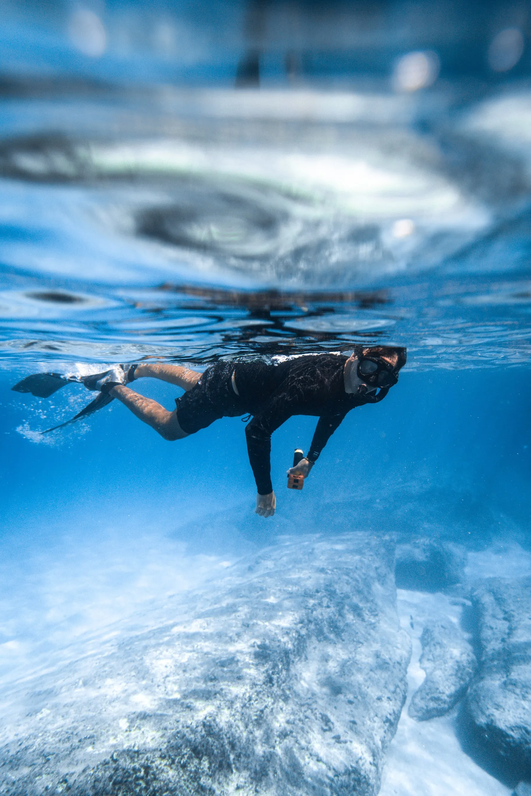 Snorkelaar die vlak onder het wateroppervlak zwemt